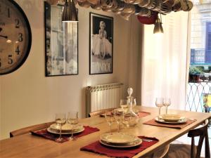 a dining room table with glasses and a clock on the wall at A Casa di Amelie in Palermo