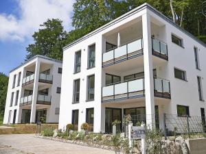 ein weißes Gebäude mit Balkonen an der Seite in der Unterkunft Haus Königsstuhl in Sellin - Penthouse mit Kamin und Balkon in Ostseebad Sellin