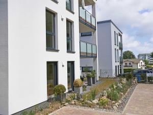 ein weißes Haus mit Pflanzen davor in der Unterkunft Haus Königsstuhl in Sellin - Penthouse mit Kamin und Balkon in Ostseebad Sellin