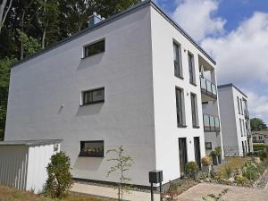 ein weißes Gebäude mit Seitenfenstern in der Unterkunft Haus Königsstuhl in Sellin - Penthouse mit Kamin und Balkon in Ostseebad Sellin