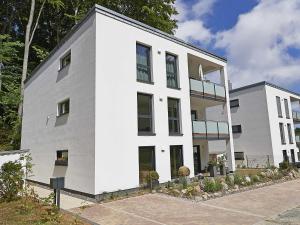 ein weißes Gebäude mit vielen Fenstern in der Unterkunft Haus Königsstuhl in Sellin - Penthouse mit Kamin und Balkon in Ostseebad Sellin