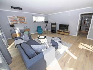 ein Wohnzimmer mit einer blauen Couch und einem Kamin in der Unterkunft Haus Königsstuhl in Sellin - Penthouse mit Kamin und Balkon in Ostseebad Sellin
