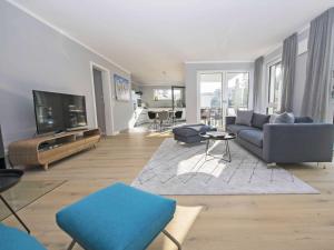 ein Wohnzimmer mit Couch und Fernseher in der Unterkunft Haus Königsstuhl in Sellin - Penthouse mit Kamin und Balkon in Ostseebad Sellin