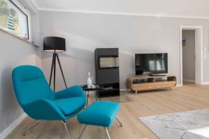 ein Wohnzimmer mit zwei Stühlen und einem Fernseher in der Unterkunft Haus Königsstuhl in Sellin - Penthouse mit Kamin und Balkon in Ostseebad Sellin + 28 Fotos