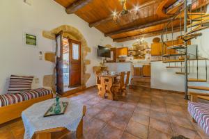 ein Wohnzimmer mit einem Tisch und einer Küche in der Unterkunft Villa Areti - Traditional Cozy Villa in Embrósneros