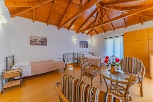 a living room with a table and chairs and a bedroom at Villa Areti - Traditional Cozy Villa in Embrósneros