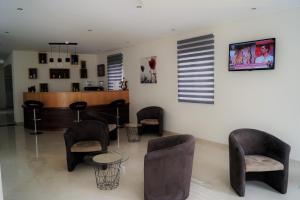 a waiting room with chairs and a bar at Angra Central Hotel in Angra do Heroísmo