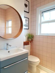 a bathroom with a sink and a toilet and a mirror at Upper Rooms Seaford in Seaford