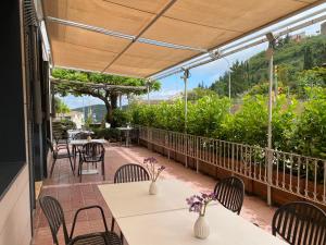 un patio con mesas y sillas y vistas a la montaña en Hostal Restaurant Roma, en Cubells