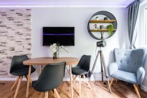a dining room with a table and chairs and a mirror at City Centre Stylish Apartment With Free Parking in Edinburgh