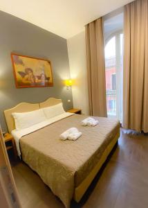 ein Schlafzimmer mit einem Bett mit zwei Handtüchern darauf in der Unterkunft Rome Travellers Hotel in Rom