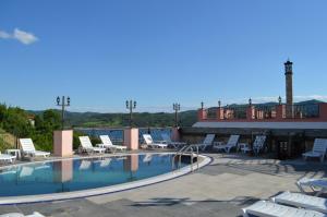 a swimming pool on top of a resort with lounge chairs at MOBI DICK Family Hotel in Glavatartsi
