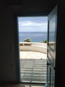 a door to a balcony with a view of the ocean at Villa Ioanna Tinos in Kionia