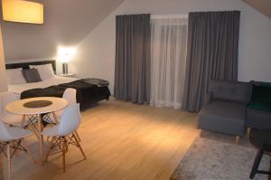 a hotel room with a bed and a table and chairs at Czarna Góra Haven in Sienna