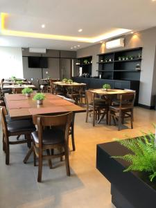 HOTEL ROYAL AMAMBAI في Amambaí: غرفة طعام مع طاولات وكراسي خشبية