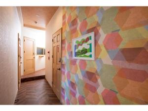 a hallway with a colorful wall with a painting on it at BEYOND HOTEL Takayama 2nd - Vacation STAY 82239 in Takayama