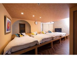 a row of beds in a room with at BEYOND HOTEL Takayama 2nd - Vacation STAY 82265 in Takayama