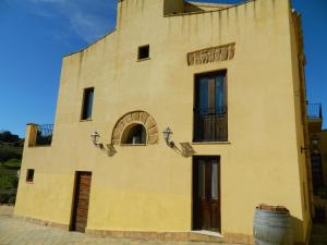 a yellow building with a barrel in front of it at Agriturismo Passo dei Briganti in Agrigento