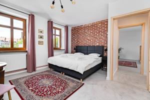 sypialnia z łóżkiem i ścianą z cegły w obiekcie Blick Apartments - Riverview Soft Loft w mieście Zgorzelec