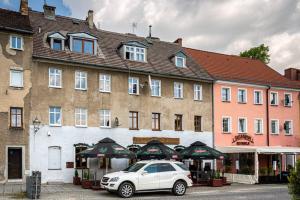 biały samochód zaparkowany przed budynkiem w obiekcie Blick Apartments - Riverview Soft Loft w mieście Zgorzelec