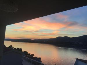 a view of a lake at sunset from a building at Apartment Cactus in Okrug Donji