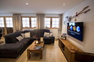 un soggiorno con divano e TV di Element Chalets Zermatt a Zermatt