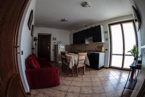 a kitchen and a living room with a table and chairs at Alla Camelia B&B in Brunello