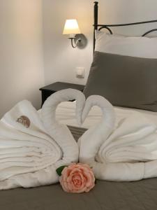 twee zwanen gemaakt van handdoeken op een bed bij Wise Owl Apartments in Banská Štiavnica