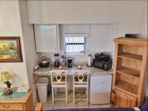 a small kitchen with a table and chairs in it at COZY QUEEN BED STUDIO NEAR DOLPHIN MALL-FIU in Miami