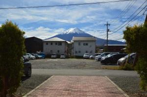 einen schneebedeckten Berg in der Ferne mit parkenden Autos in der Unterkunft Minamitsuru-gun - House - Vacation STAY 82283 in Fujikawaguchiko