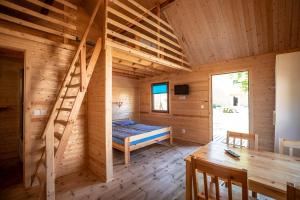drewniany domek z łóżkiem i drewnianą podłogą w obiekcie O.W.Cynamon w Dziwnowie