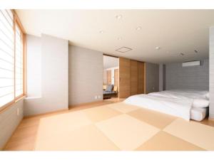 een slaapkamer met een wit bed en een groot raam bij BEYOND HOTEL Takayama 3rd - Vacation STAY 82217 in Takayama