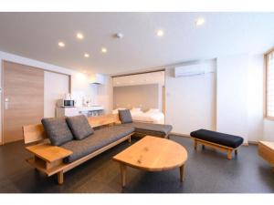 a living room with a couch and a bed at BEYOND HOTEL Takayama 3rd - Vacation STAY 82217 in Takayama