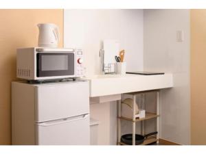 a microwave sitting on top of a counter in a kitchen at BEYOND HOTEL Takayama 3rd - Vacation STAY 82215 in Takayama