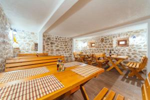 a restaurant with wooden tables and wooden benches at Apartments EcoNature in Virpazar