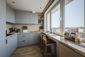 a kitchen with white cabinets and a large window at Best View In Apartment in Liepāja