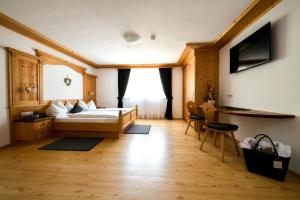 a bedroom with a bed and a desk in a room at Apartments Sunela in Selva di Val Gardena
