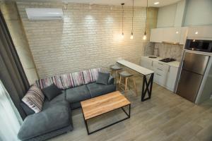 a living room with a couch and a table in a kitchen at New Wave 1 in Batumi
