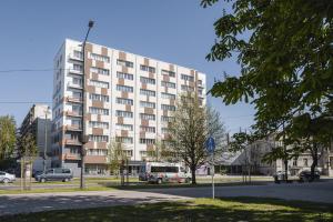 un grande edificio con macchine parcheggiate di fronte di Best View In Apartment a Liepāja