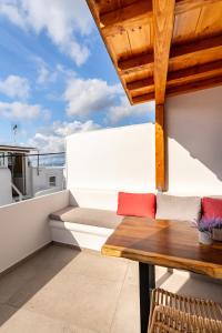 a balcony with a wooden table and a bench at LevandaMykonos in Mýkonos City