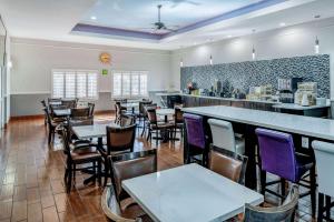 a restaurant with tables and chairs and a bar at La Quinta by Wyndham Alamo-McAllen East in Alamo