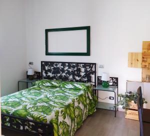 - une chambre dotée d'un lit avec un couvre-lit noir et vert dans l'établissement Francesca house, à Erba