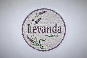 a embroidered sign with lavender on a white wall at LevandaMykonos in Mikonos