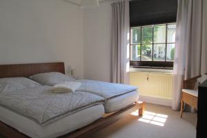 Schlafzimmer mit einem Bett und einem Fenster in der Unterkunft Gästehaus Fichtenwäldche in Kelberg