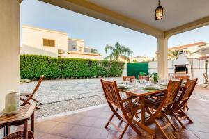 a patio with a table and chairs and a fireplace at Altura Prime - 5 Suites, Private Pool and Parking, Walk to Beach in Altura