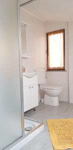 bagno bianco con servizi igienici e lavandino di Apartments Milica a Umag (Umago)