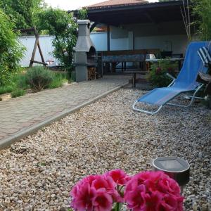 a garden with a fire pit and pink flowers at Aliz Apartman in Nyíregyháza