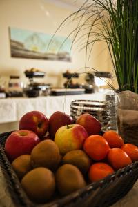 einen Korb mit Äpfeln und Orangen in einer Küche in der Unterkunft Hotel Meeresruh Garni in Cuxhaven