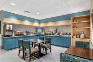 a restaurant with blue cabinets and a table and chairs at Comfort Inn & Suites Calhoun South in Calhoun