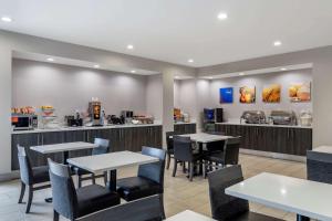 a restaurant with tables and chairs and a counter at Comfort Suites McDonough Atlanta South in McDonough